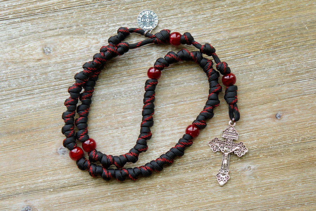 The Blood of Christ - Red and Black Knotted Rope Rosary | Unleash the power of prayer with this durable, premium paracord rosary designed by Sanctus Servo. This handmade Catholic gift features bold red Our Father beads and intricately knotted Hail Mary beads, symbolizing Christ's passion.