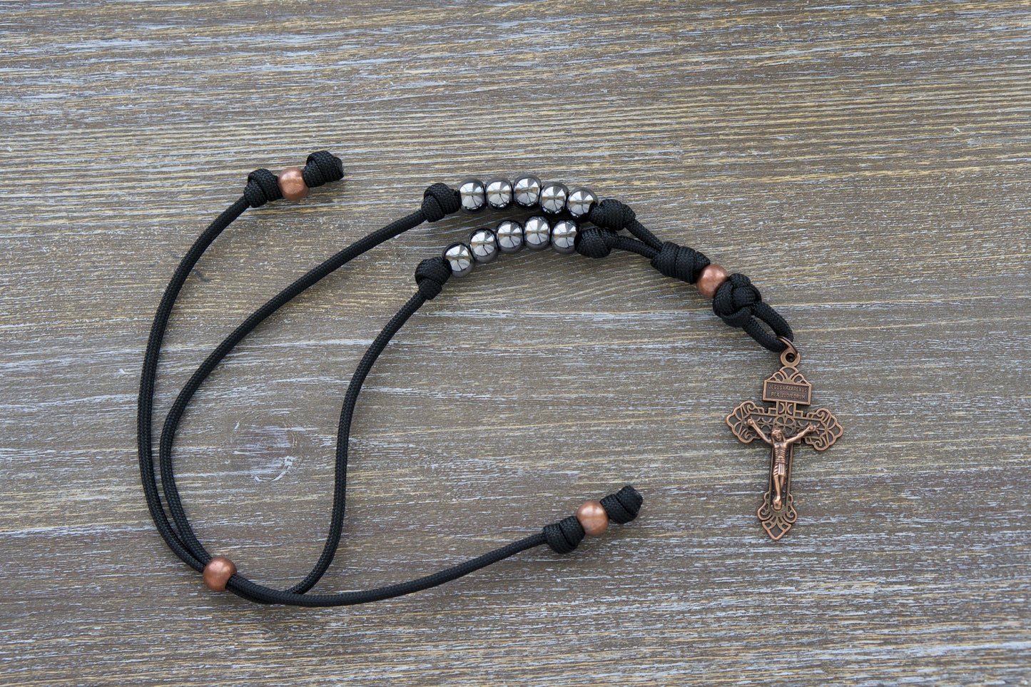 Ancient Armor Rearview Mirror Rosary with Black Paracord, Antique Copper Beads and Gunmetal Hail Mary beads. Perfect Accessory for Your Vehicle's Rearview Mirror to Inspire Faith and Strength in Life's Battles.