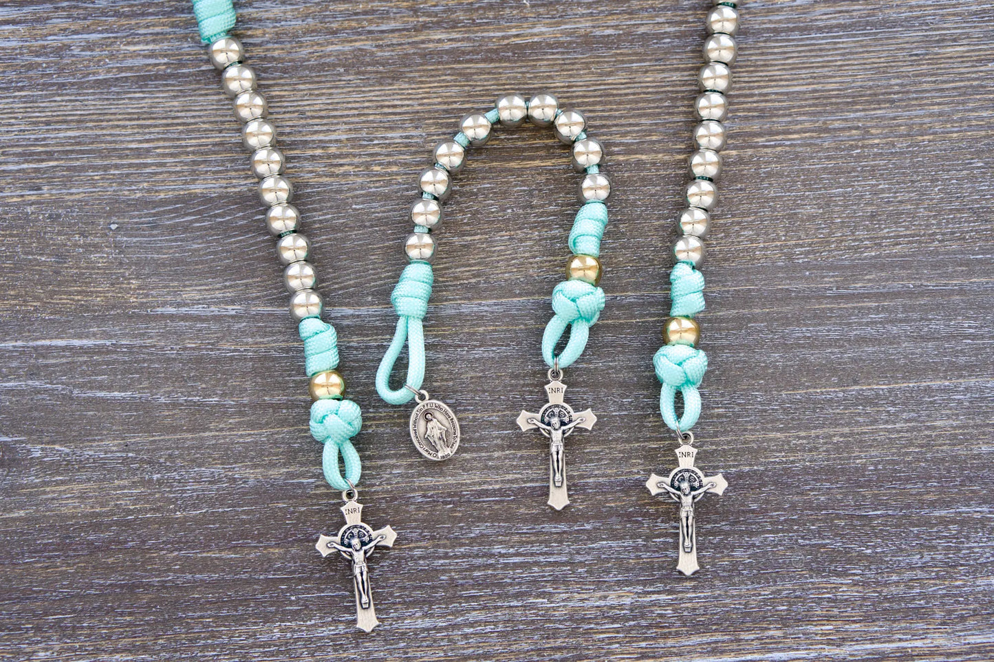 August Queen of the Heavens kids' paracord rosary with teal blue rope, royal silver and gold beads, 2" St. Benedict crucifix, and 3/4 inch Miraculous Medal