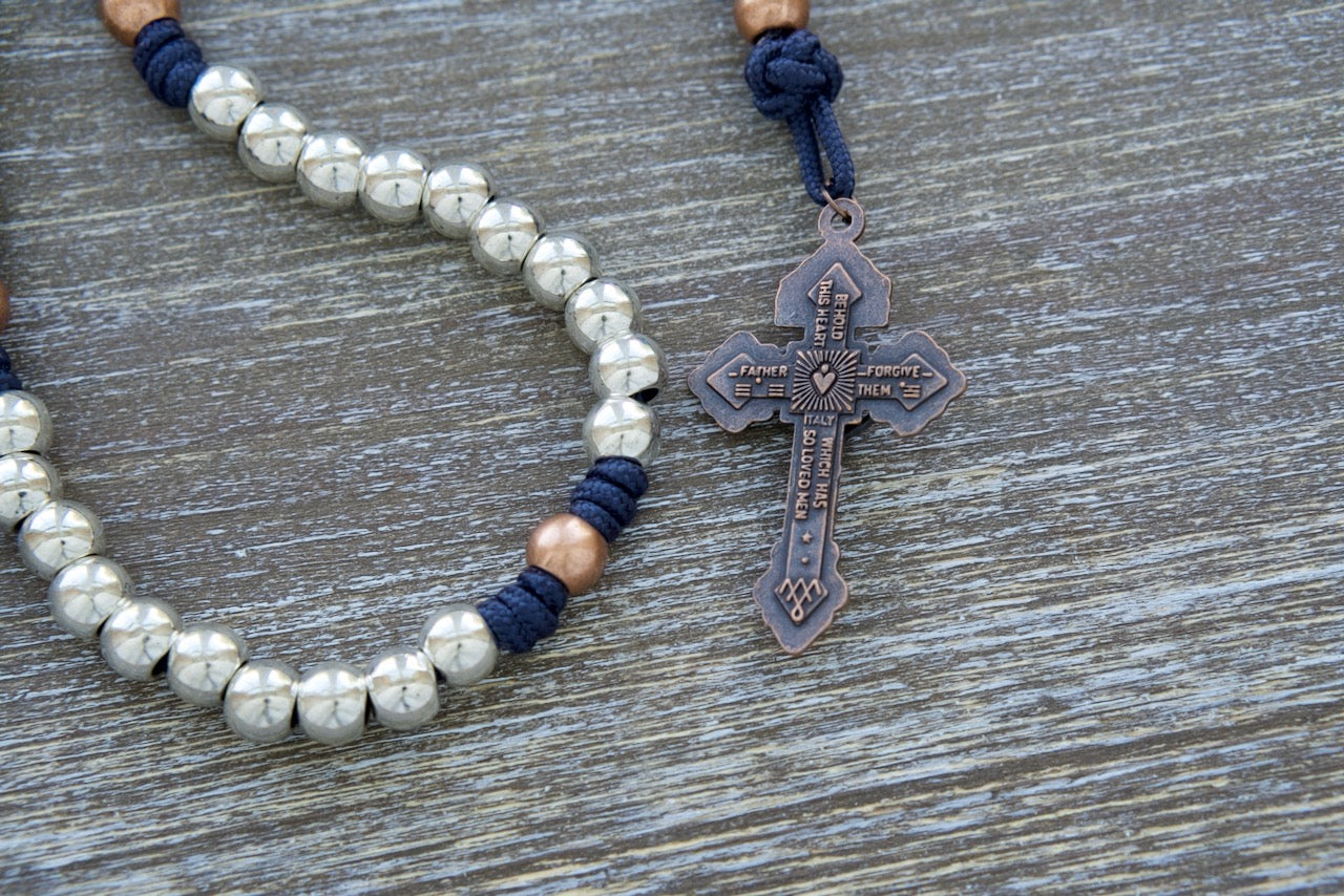 Navy blue, stainless steel, and copper premium paracord rosary with St. Benedict centerpiece and 2" pardon crucifix for spiritual protection and guidance in life's battles.