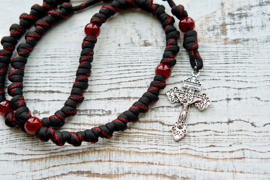 Embrace the power of The Blood of Christ - Red and Black - Knotted Rope Rosary, expertly crafted with durable paracord 550 rope by our devoted Catholic family. This unique rosary symbolizes the Passion with bold red Our Father beads and intricately knotted Hail Mary beads.