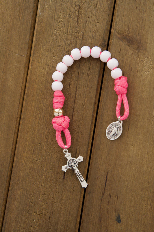 A children's pink and white pocket paracord rosary with durable paracord 550, smaller 10mm beads in white Hail Mary and rose gold Our Father colors, perfect for kids learning to pray.