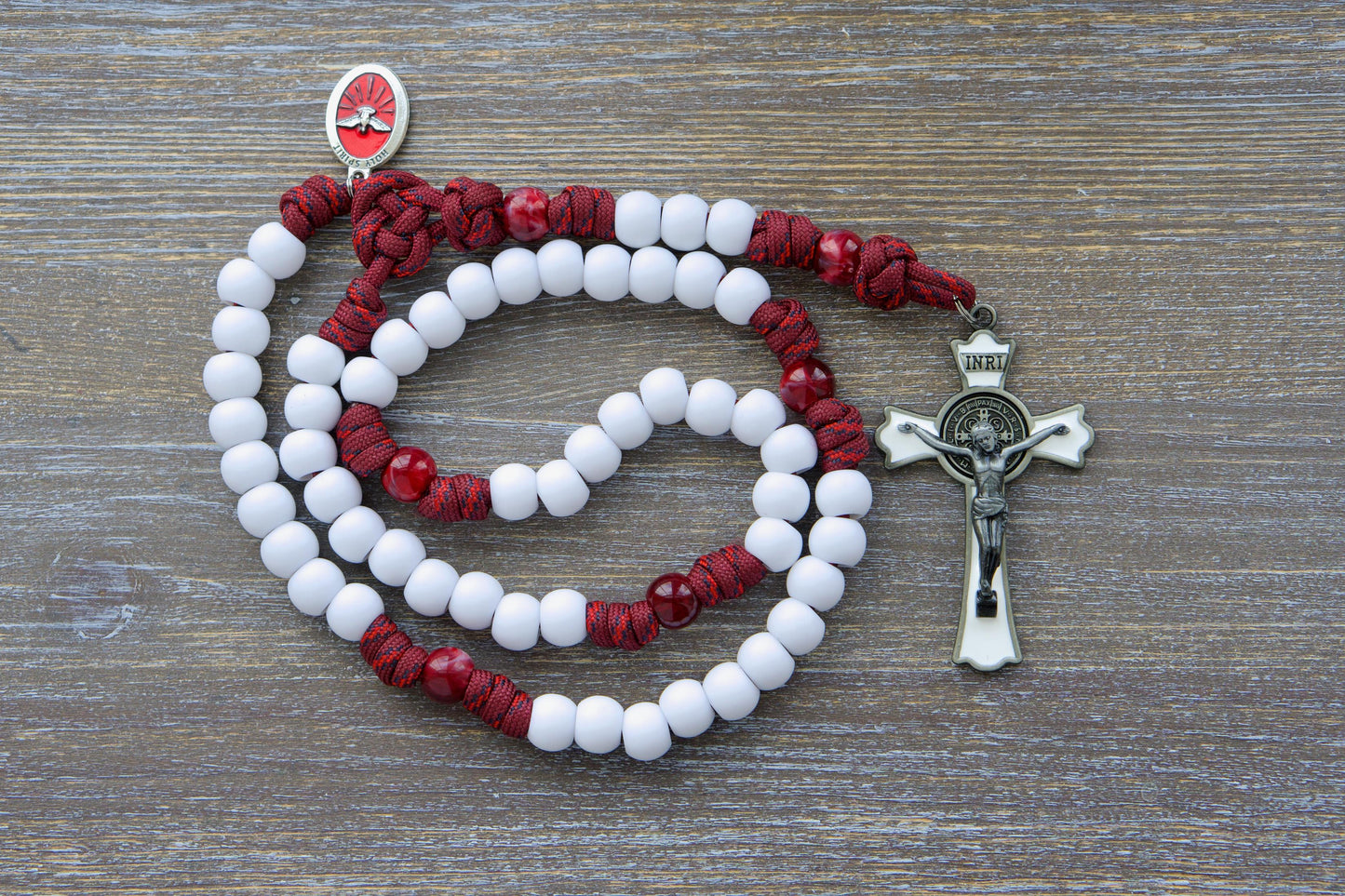 Crimson Shield - Holy Spirit Confirmation Rosary: A handmade 5-decade paracord rosary in maroon red with black or white Hail Mary beads, featuring a gleaming black (or white) enamel St. Benedict crucifix and a vibrant red Holy Spirit medal.
