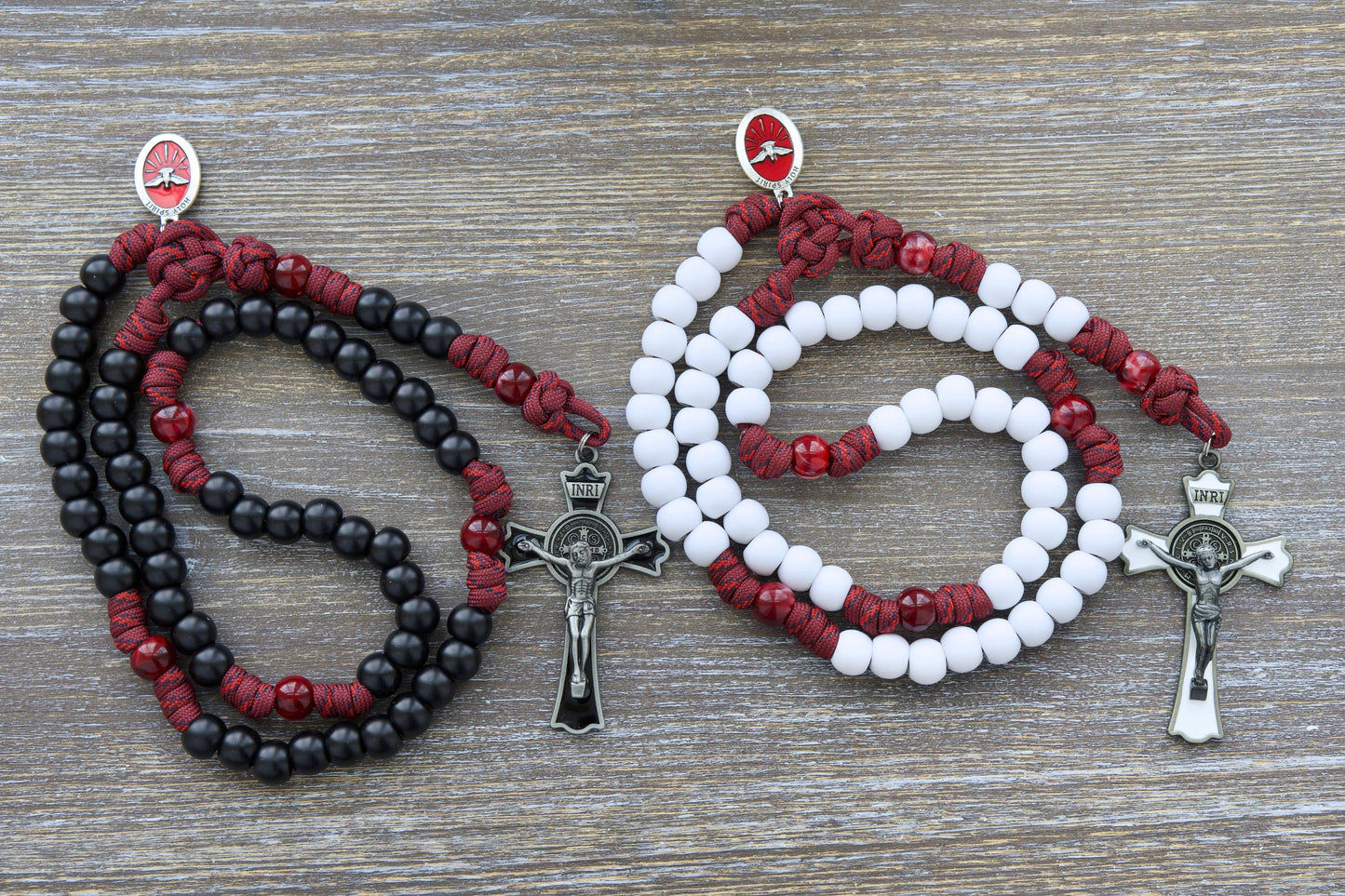 A vibrant maroon red paracord rosary, "The Crimson Shield," featuring black (or white) Hail Mary beads and a gleaming black (or white) enamel St. Benedict crucifix.