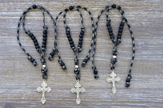 The Demon Destroyer - Rearview Mirror Rosary. A sleek and powerful 9-inch (expandable to 13 inches) paracord rosary designed for Catholic devotion on-the-go, featuring ten black Hail Mary beads, a silver Pardon crucifix, one silver Our Father bead, and expertly handmade by our small Catholic family.