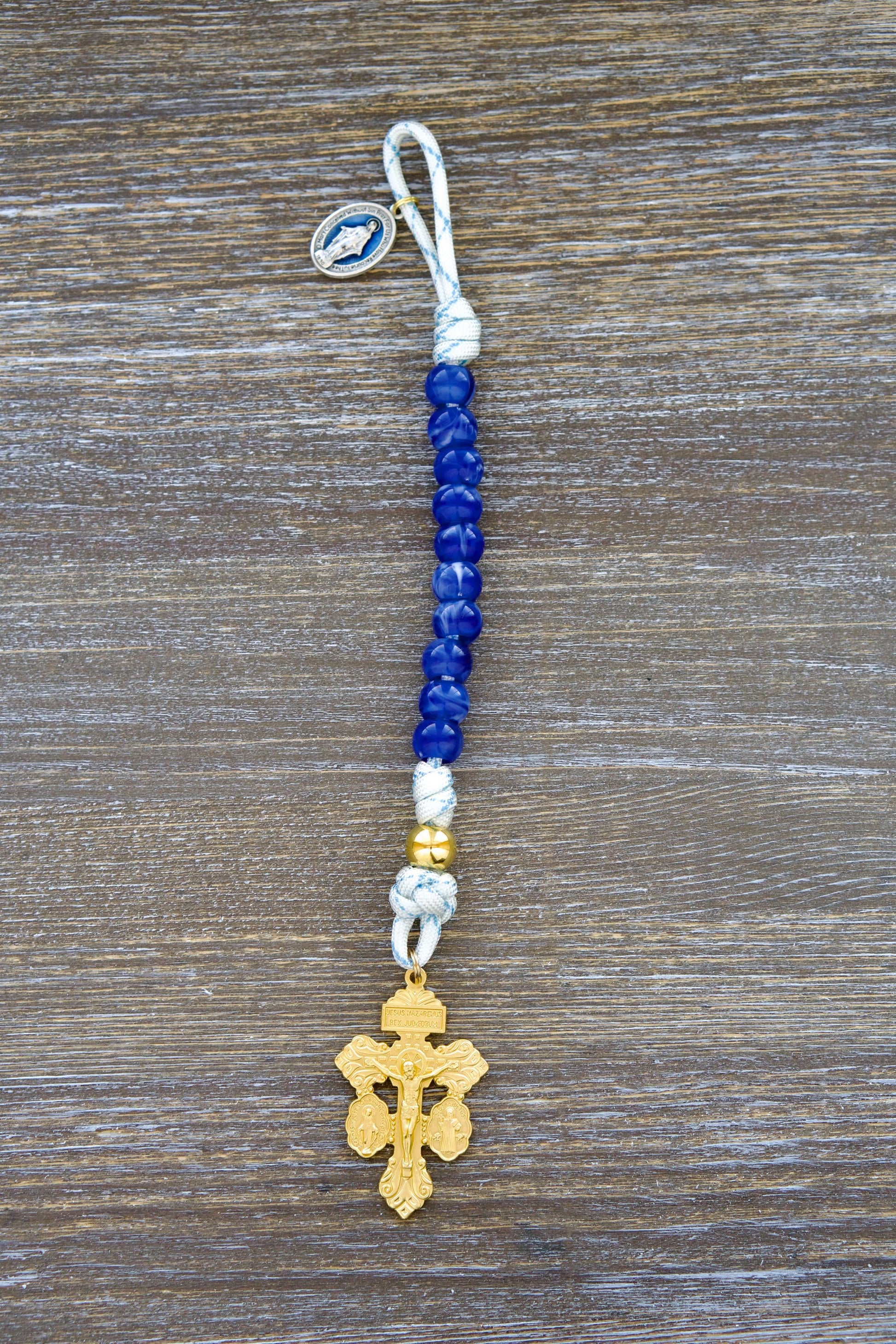 Divine Light Pocket Paracord Rosary - Single decade rosary featuring white paracord with blue accents, gold Our Father bead, unique Miraculous blue acrylic Hail Mary beads, a blue enamel Miraculous Medal, and a gold 'Triple Threat' Pardon Crucifix.