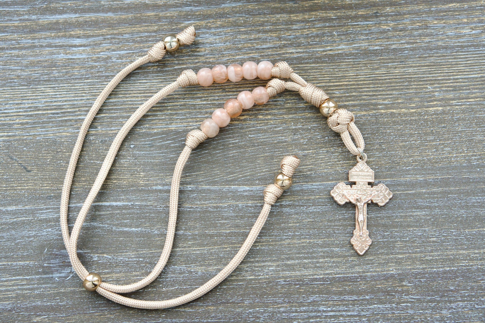 Gate of Heaven Rearview Mirror Rosary: Handmade tan/rose gold paracord rosary with rose gold Our Father bead, milky pink Hail Mary beads, and a unique rose gold Pardon Crucifix centerpiece.
