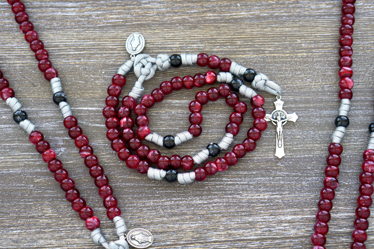Gemstone Colored - 5 Decade Paracord Rosary featuring four beautiful gemstone color options - Garnet Red, Ingolite Blue, Emerald Green or Magenta, adorned with a standard 2" St. Benedict Crucifix and Miraculous Medal devotional medal.