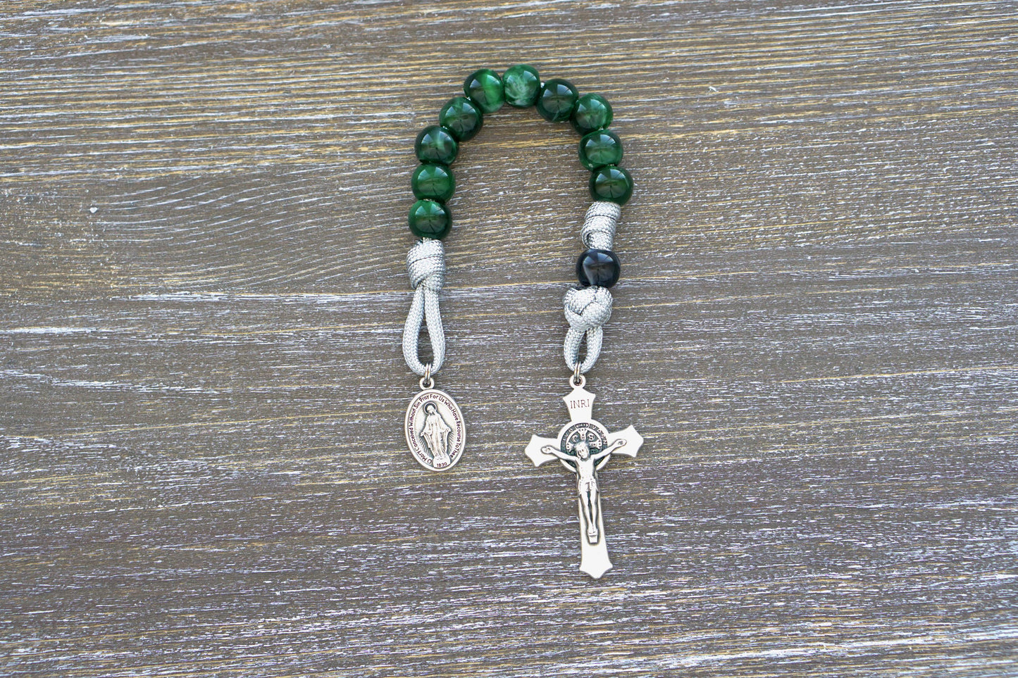 Handmade Gemstone Colored single decade paracord rosary with acrylic beads, Miraculous Medal, and St. Benedict Crucifix; perfect for prayer and life's battles. Choose from Garnet Red, Emerald Green, Ingolite Blue, or Magenta colors.