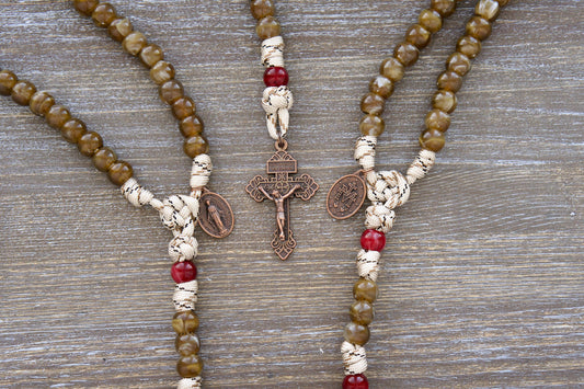 A handcrafted Heavenly Rose paracord rosary, featuring brown camo paracord, creamy brown Hail Mary beads, creamy maroon Our Father beads, and a copper Miraculous Medal.