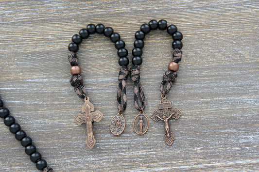 Heavy Duty Hail Mary Pocket Rosary: Matte black acrylic Hail Mary beads, antique copper Our Father bead, crucifix, and Miraculous medal on durable paracord cord.
