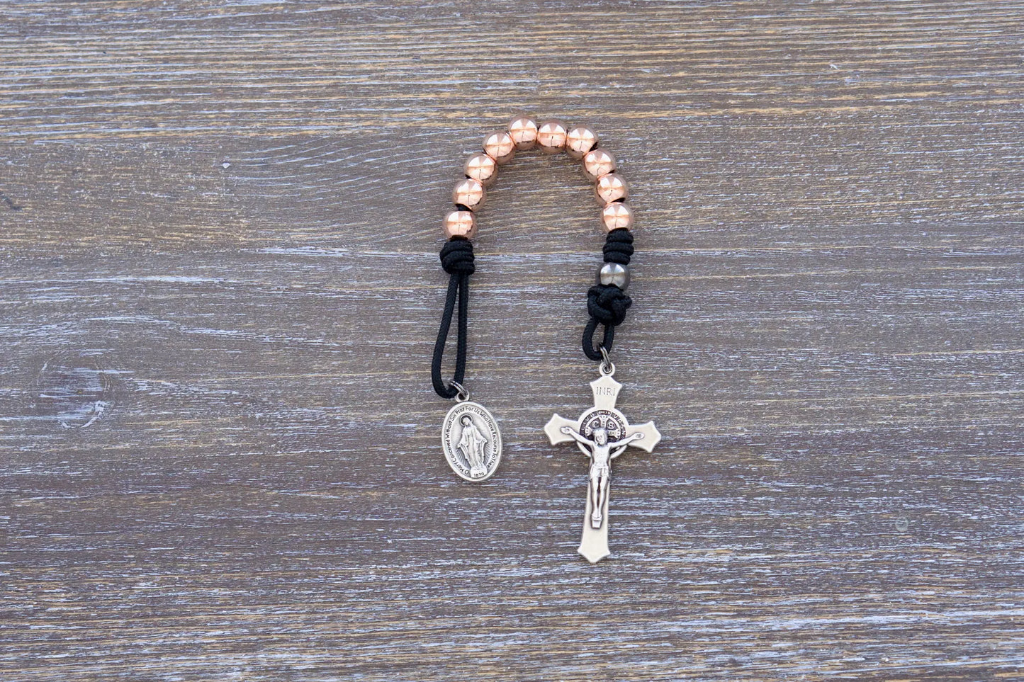 Immaculate Strength premium metal paracord rosary featuring black rope and rose gold beads, sleek and durable.