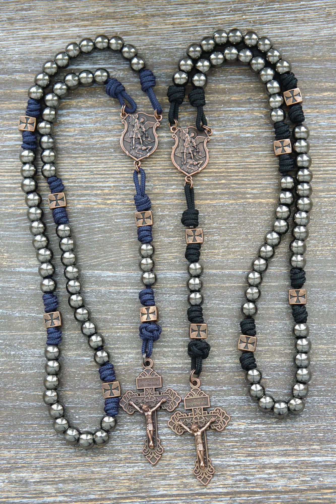 Black or navy blue paracord rosary featuring gunmetal Hail Mary beads, copper Our Father beads, St. Michael centerpiece medal, and crucifix.