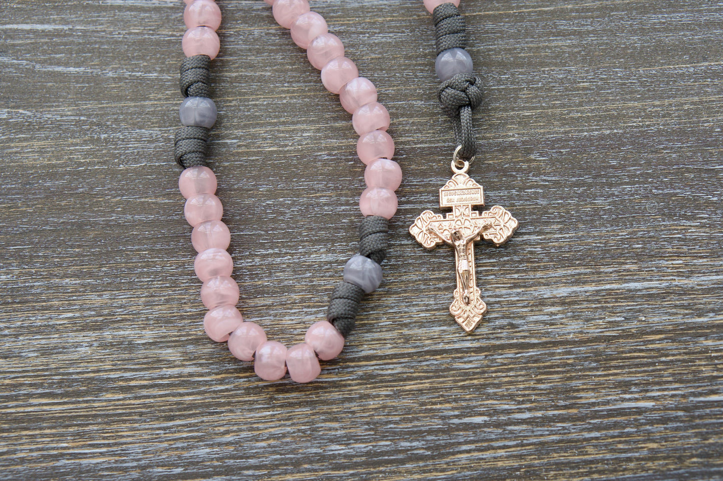 Handcrafted "Ite Ad Joseph" 5-Decade Rosary featuring grey and milky pink colors, 12mm acrylic beads, a St. Joseph medal, and a radiant rose gold Pardon crucifix.