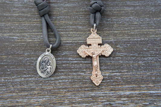 Pocket paracord rosary, "Ite Ad Joseph," featuring grey paracord, milky grey Our Father bead, contrasting milky pink Hail Mary beads, a rose gold Pardon Crucifix, and a St. Joseph devotional medal.