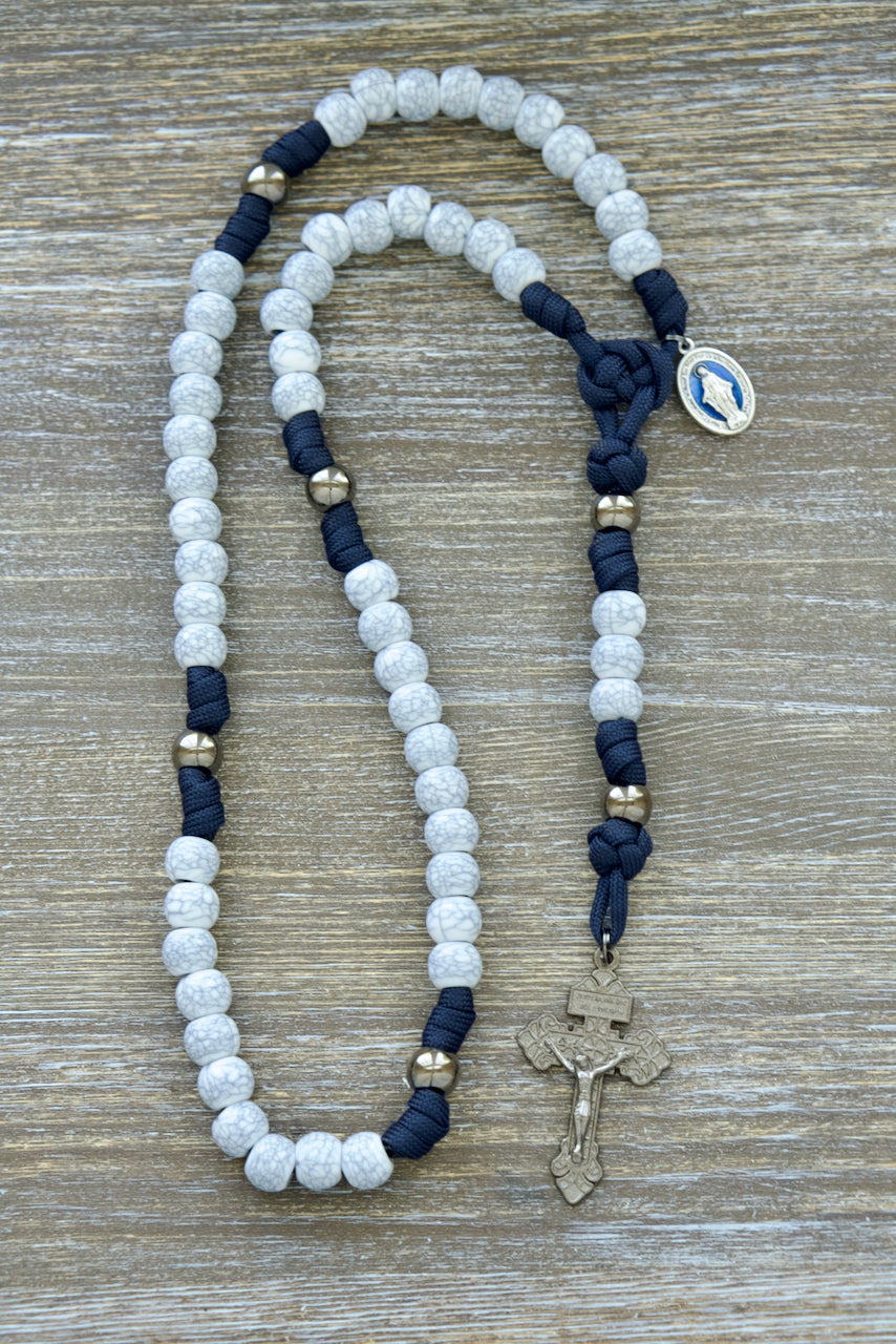 Marian Stronghold - 5 Decade Paracord Rosary with gunmetal Our Father beads, cracked ivory Hail Mary beads, and blue enamel Miraculous Medal. Handmade Catholic gift for adults featuring a durable, unbreakable navy blue paracord design.