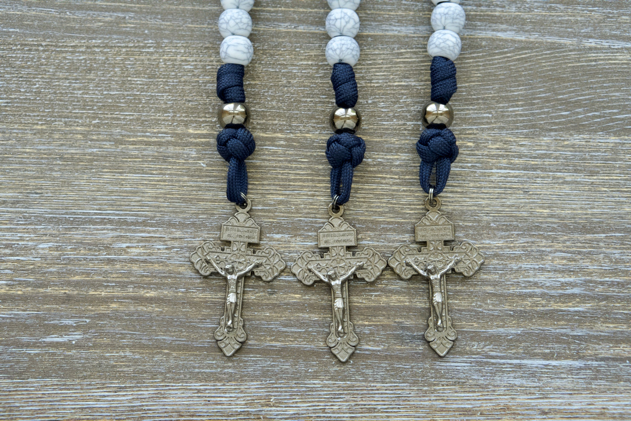 Marian Stronghold - Pocket Paracord Rosary, featuring premium quality materials and unbreakable strength in a durable design. This elegant rosary boasts 12mm beads, gunmetal Our Father beads, cracked ivory Hail Mary beads, and a matching 2-inch pardon crucifix.