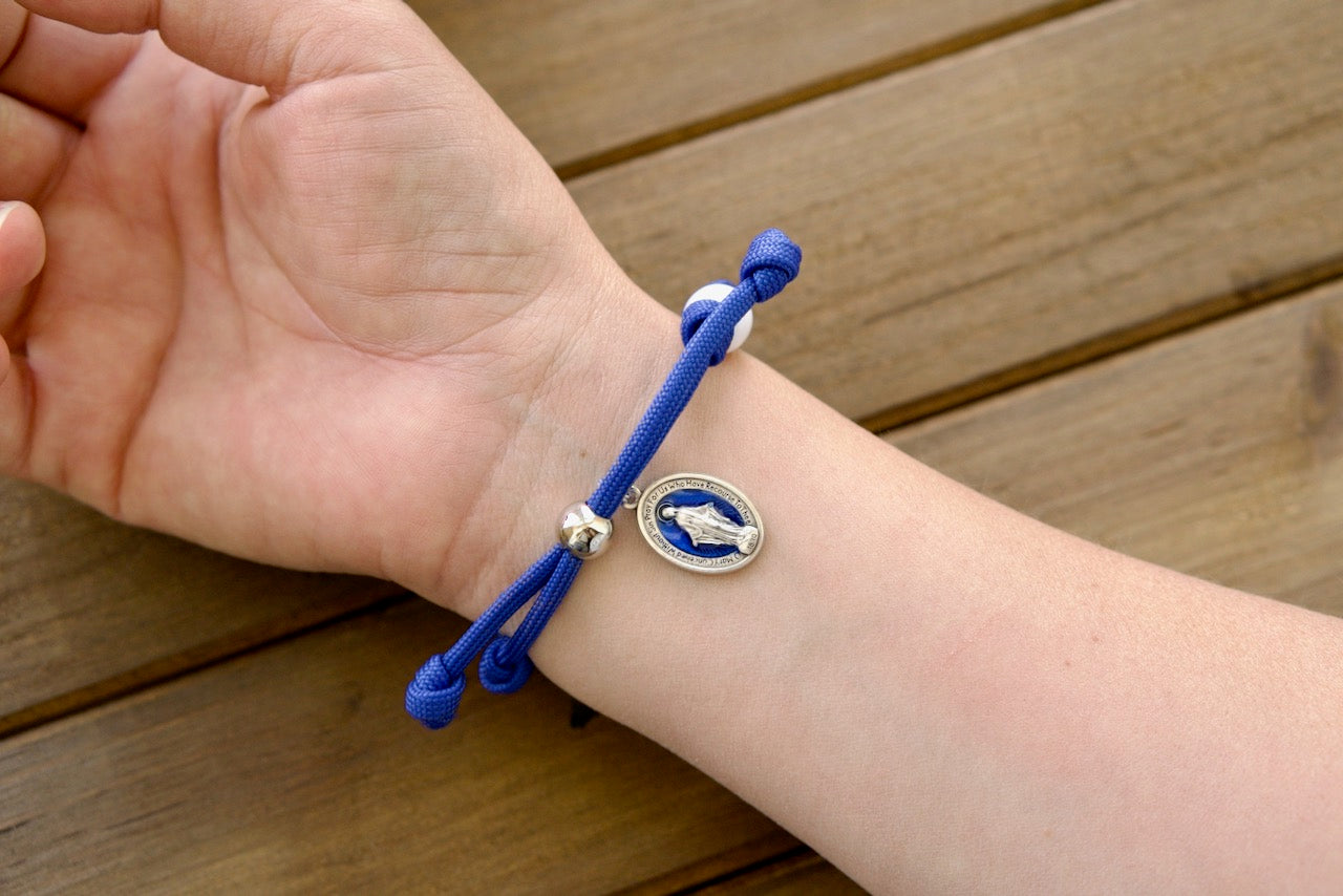 Unbreakable Our Lady of the Miraculous Medal Rosary Bracelet, featuring a stunning blue enamel Miraculous medal in premium paracord with durable beads for strengthening faith and battling life's challenges. Catholic gift for devotion on-the-go.
