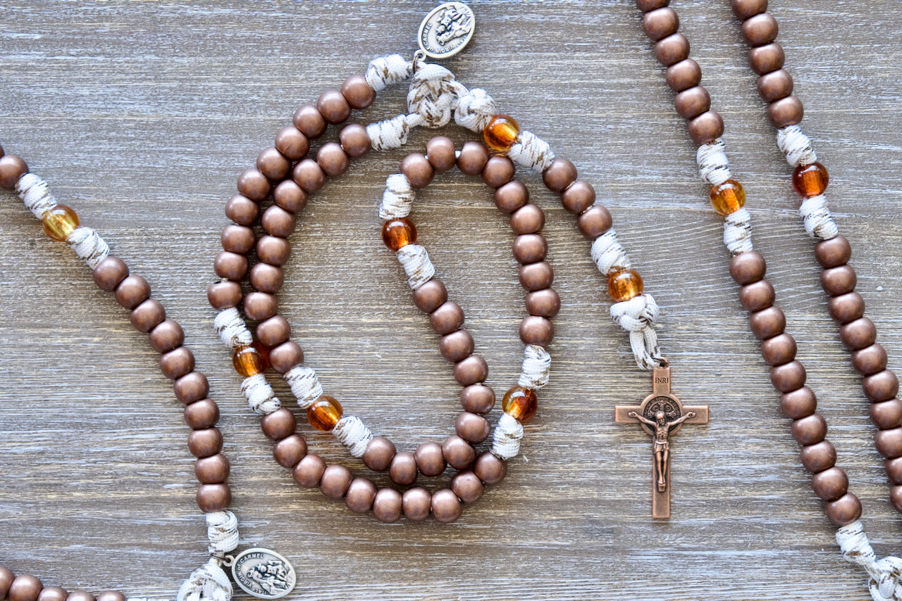 Our Lady of Mount Carmel 5 Decade Paracord Rosary, featuring antique copper Hail Mary beads, transparent brown Our Father beads, a copper St. Benedict crucifix, and premium paracord rope with copper-infused strands for unwavering strength and beauty.