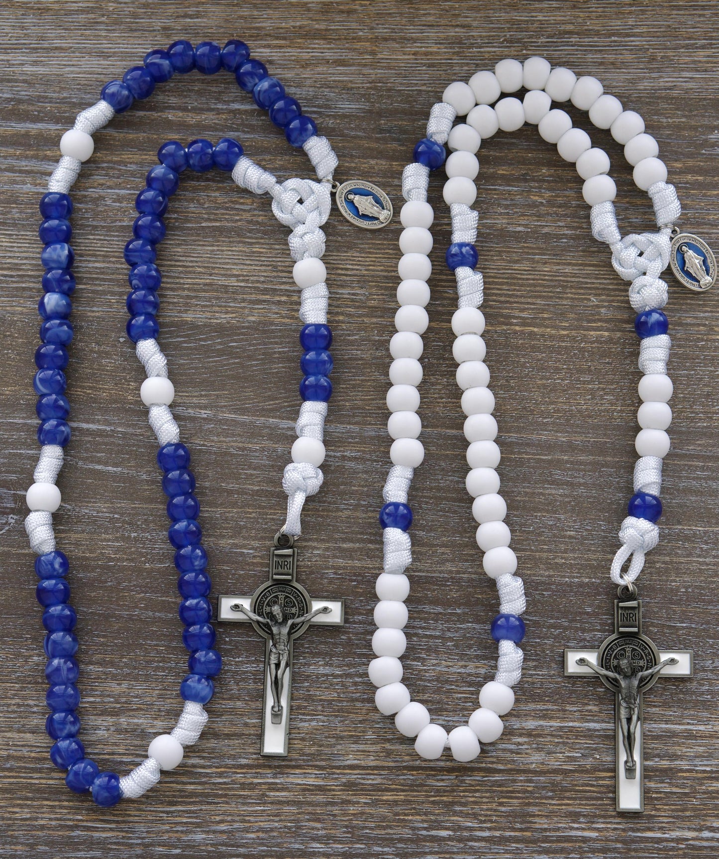 Our Lady's Mantle" 5 Decade Paracord Rosary: Two stylish options featuring white paracord, blue enamel Miraculous Medal, and a white enamel St. Benedict crucifix. Handmade with durable 12mm matte white and milky "miraculous blue" acrylic beads for enhanced devotion during prayer and spiritual warfare.