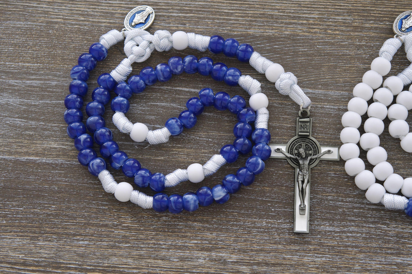 Our Lady's Mantle 5 Decade Paracord Rosary: A handcrafted rosary featuring durable white paracord, a blue enamel Miraculous Medal, and an elegant white enamel St. Benedict crucifix.