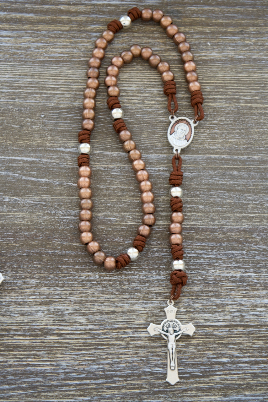 St. Padre Pio Stainless Steel Paracord Rosary: Handmade Catholic rosary featuring 275 paracord, stainless steel beads, antique copper Hail Mary beads, shiny silver Our Father beads, stunning brown enamel St. Padre Pio medal, and 2" St. Benedict crucifix. Perfect for devotion and faith on your Catholic journey. Shop now!
