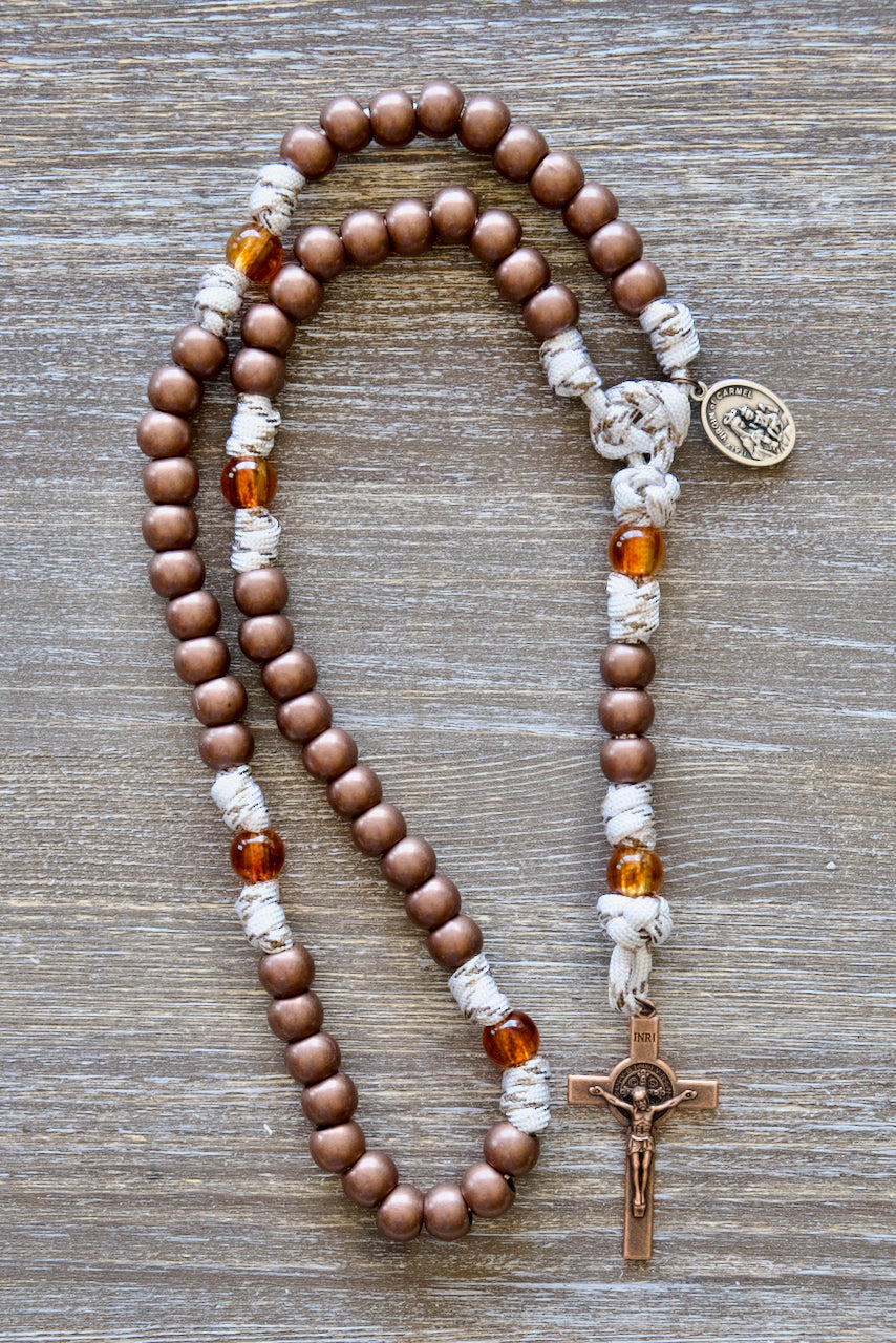 Our Lady of Mount Carmel 5 Decade Paracord Rosary featuring antique copper acrylic Hail Mary beads, transparent brown Our Father beads, a copper St. Benedict crucifix, and premium paracord with copper-infused strands.