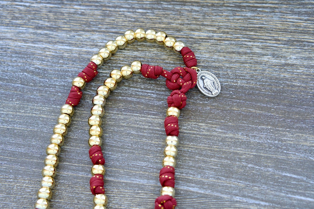Scarlet Crown - Kid's 5 Decade Paracord Rosary with red paracord, gold beads, and a gold-ribbon finish, featuring a 2" gold Pardon Crucifix and a 1 inch Miraculous Medal for spiritual guidance and protection.