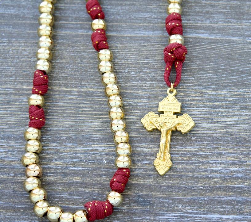 Scarlet Crown Kid's 5 Decade Paracord Rosary with gold beads, red paracord rope, and luxury accents, including a gold ribbon, golden Hail Mary and Our Father beads, a 2" gold Pardon Crucifix, and a 1 inch Miraculous Medal.