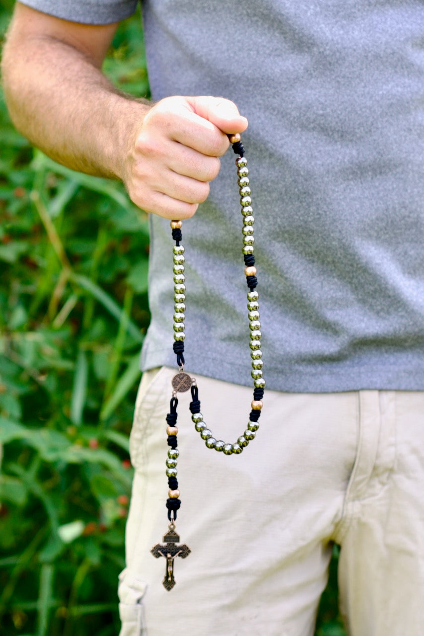 This beautifully crafted rosary, featuring black paracord and metal alloy beads, offers a durable and reliable companion for your spiritual journey. The antique copper Hail Mary and Our Father beads create a visually striking contrast that enhances its spiritual resonance. Complete with an intricate St. Benedict centerpiece and Pardon Crucifix, this premium rosary is perfect for those seeking strength and guidance on the path of discipleship.
