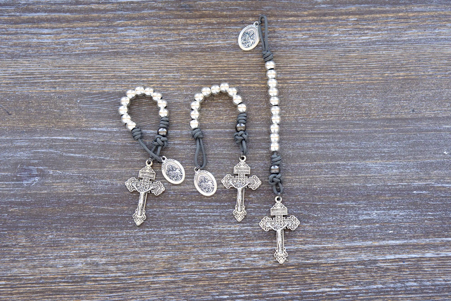 Premium metal paracord rosary featuring gray rope, silver beads, St. Joseph medal, and pardon crucifix.