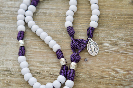Unleash the power of this Purple and White 5 Decade Paracord Rosary, a premium spiritual weapon for women! Featuring a beautiful purple and white design, a 2" St. Benedict Crucifix, and a Miraculous Medal, this durable and unbreakable Catholic gift is perfect for prayer on the go.