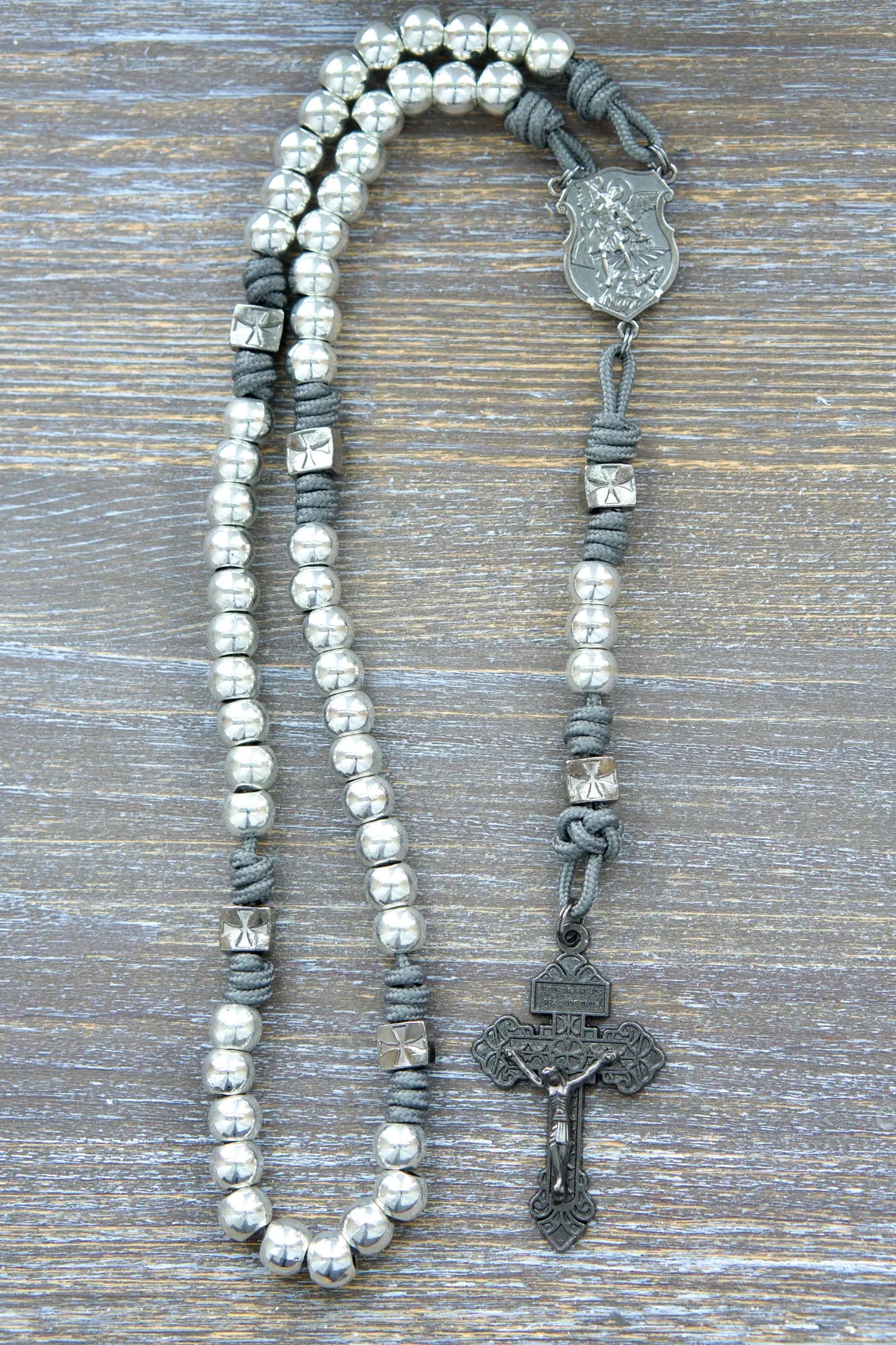 Metal paracord rosary with gunmetal St. Michael centerpiece, crucifix, and metal silver Hail Mary beads in iron gray rope color.