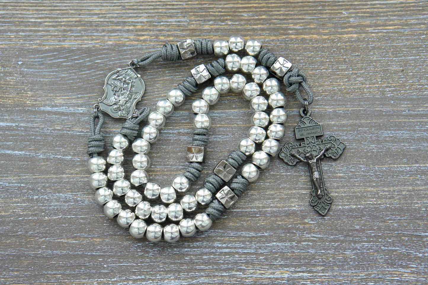 Bold gunmetal "Reclaim Christendom" paracord rosary with iron gray rope, silver metal Hail Mary Beads and navy gunmetal crucifix and centerpiece.