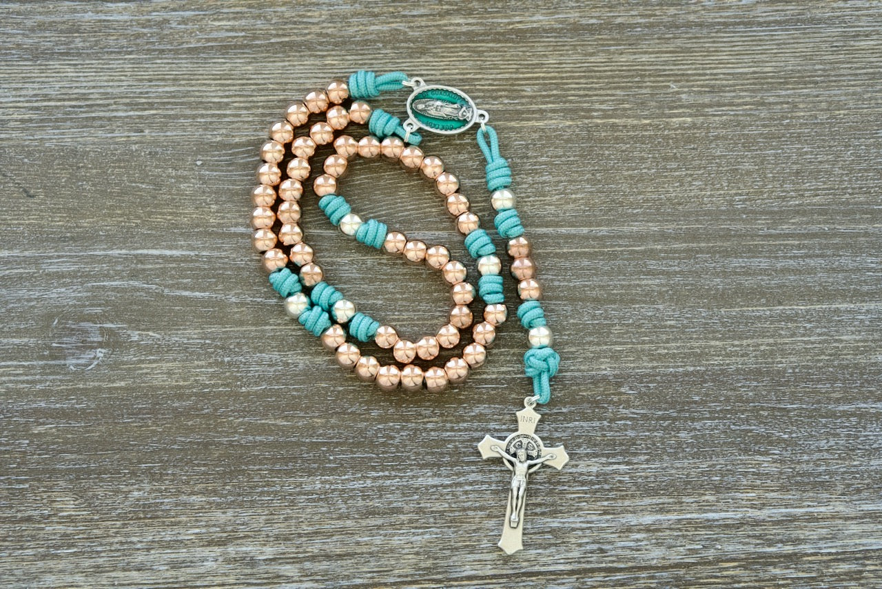 Stunning Rosa Mystica paracord rosary with teal blue rope, metal alloy beads, and Our Lady of Guadalupe medal for faithful Catholic sisters seeking durable spiritual weapons.