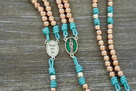 The Rosa Mystica Paracord Rosary - Our Lady of Guadalupe. Durable, premium paracord rosary with teal blue rope, metal alloy beads, and an enamel Our Lady of Guadalupe centerpiece. Perfect for Catholic warriors seeking spiritual strength and indulgences.