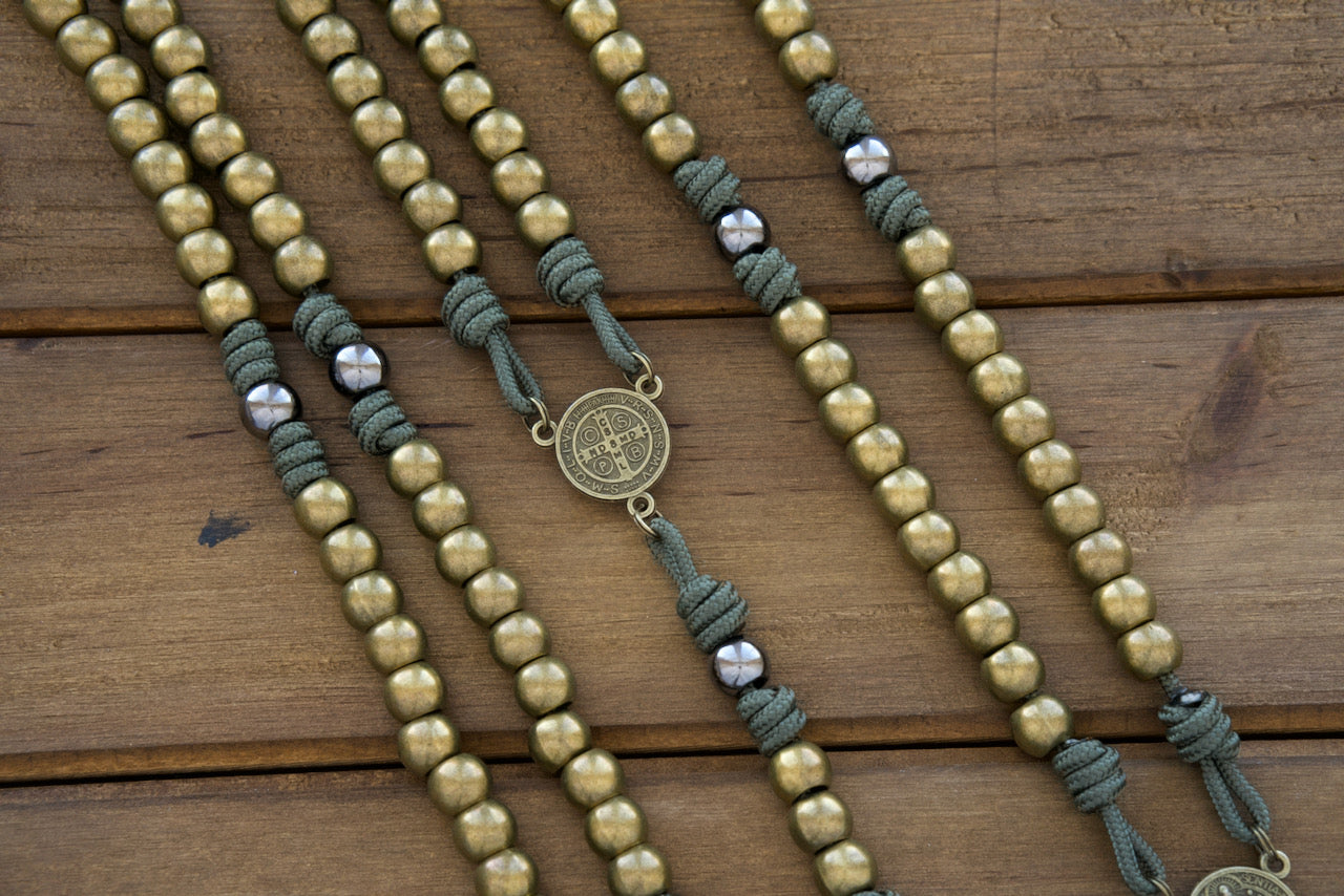 A high-quality, durable paracord rosary featuring stainless steel olive beads and a powerful St. Benedict medal for spiritual protection. Perfect for traditional Catholics seeking a unique blend of modern materials and timeless devotion.