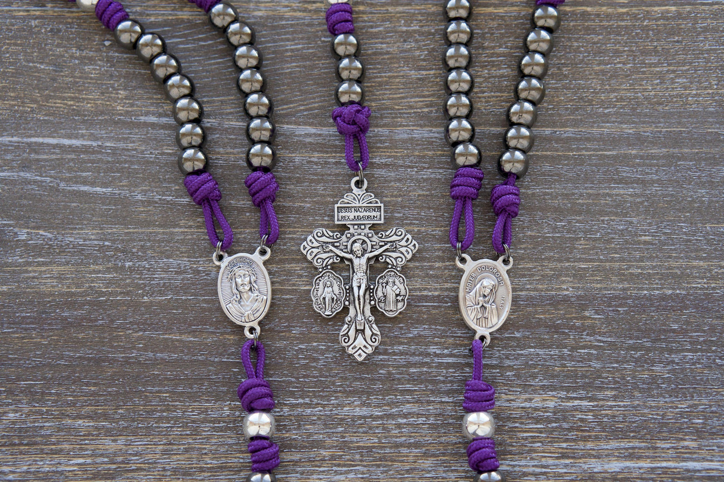 Sturdy purple paracord Servite Rosary chaplet featuring 10mm silver 'Our Father' beads, gunmetal 'Hail Mary' beads, and a centerpiece medal depicting Mater Dolorosa (Our Lady of Sorrows) on one side and Ecce Homo on the other.