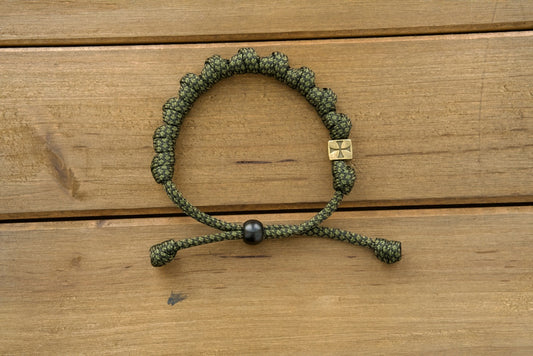 Durable olive metal alloy rosary bracelet with adjustable army green/black paracord, perfect for active Catholics seeking to strengthen their spiritual armor.