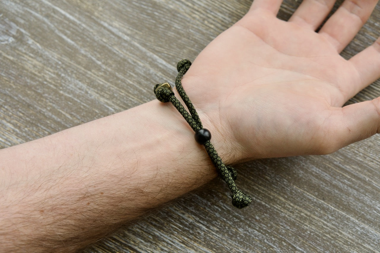 Shield of Faith Rosary Bracelet - Durable olive metal alloy Our Father beads, adjustable army green/black paracord rope, perfect for strengthening spiritual armor and active lifestyles. Unbreakable Catholic gift.