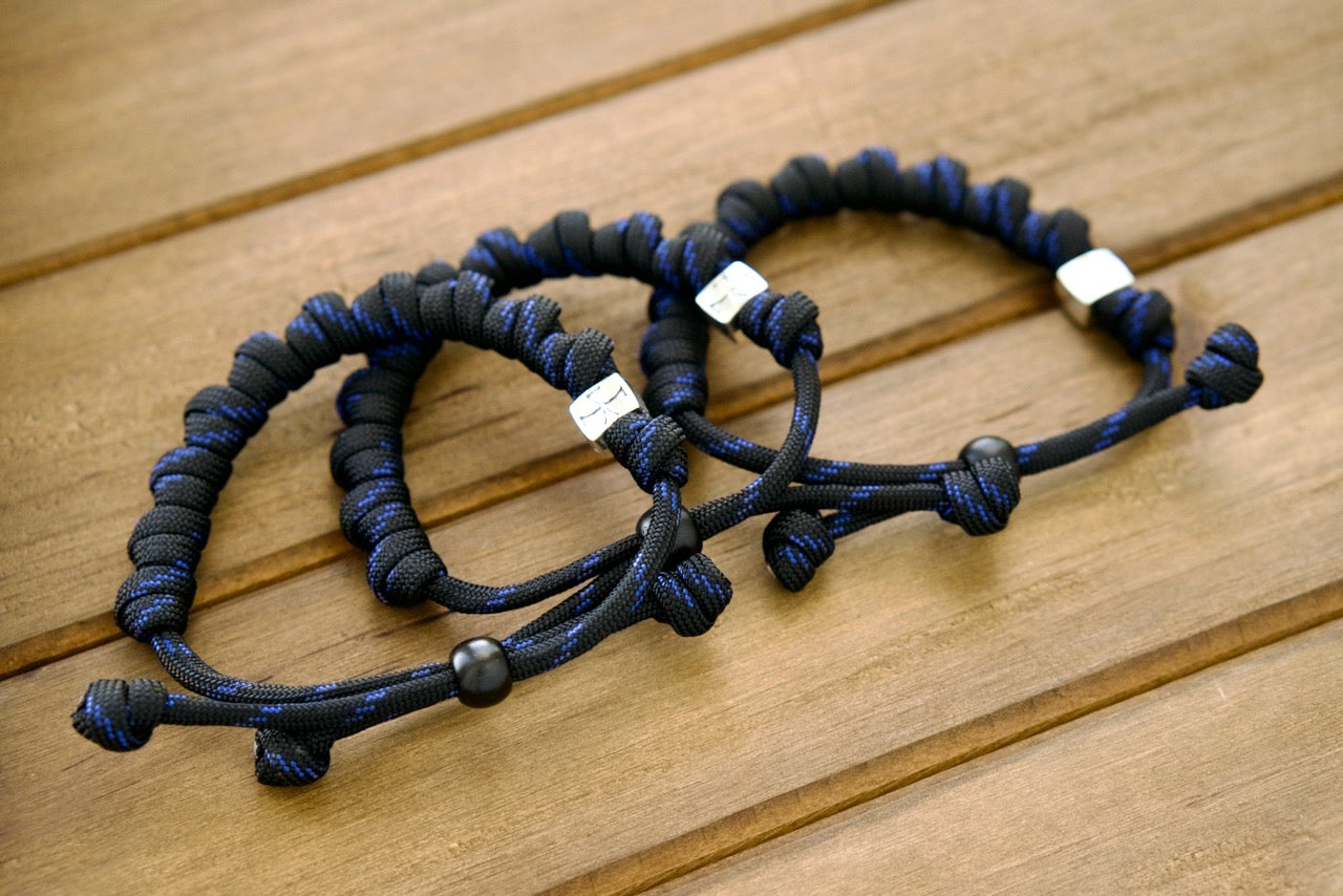 The Solemn Crusader - Rosary Bracelet, a unique blend of spirituality and modern durability crafted with precision for those who seek strength in their faith. Featuring a silver Crusader Our Father bead and high-quality black and blue paracord 550, this premium rosary bracelet is perfect for Catholic devotees on the go.
