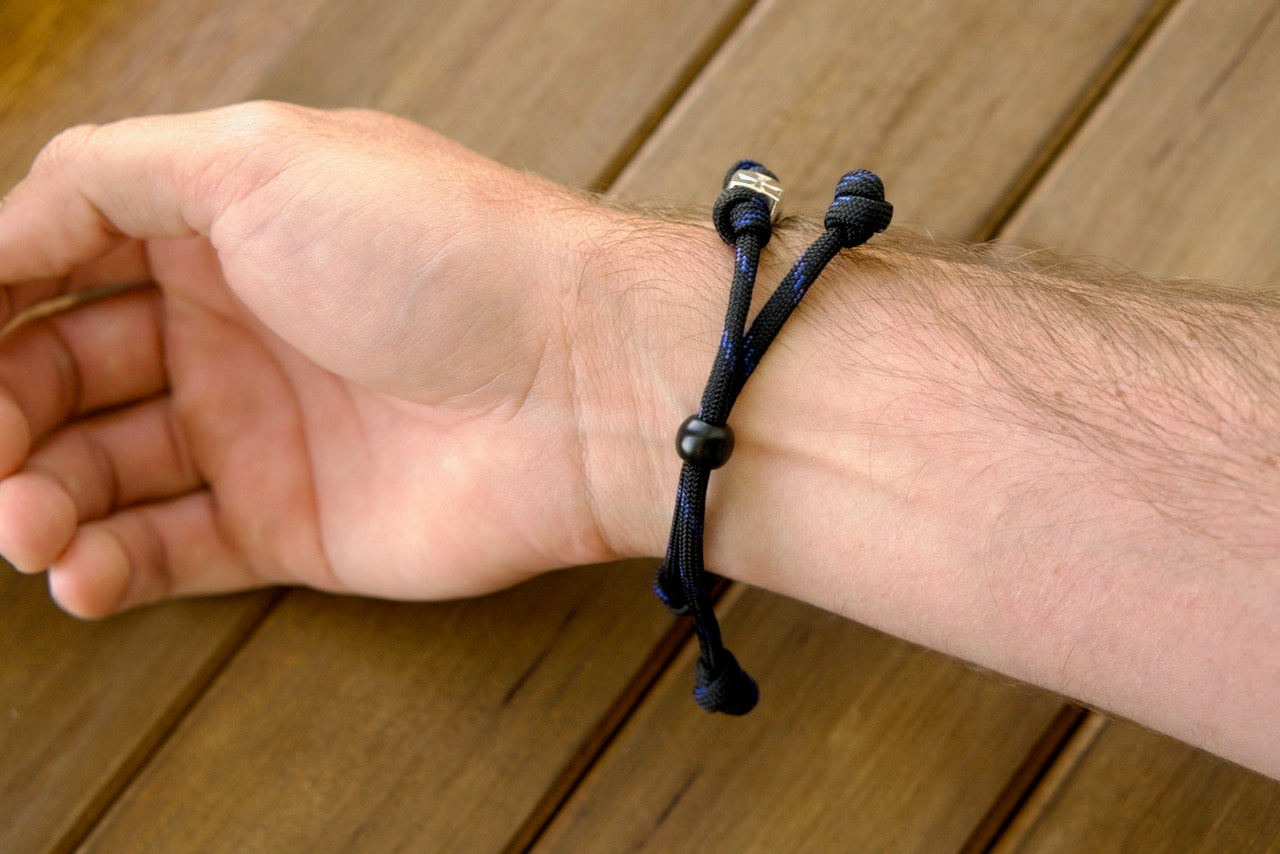 Embrace your faith with the Solemn Crusader - Rosary Bracelet, a durable, premium paracord rosary bracelet featuring black and blue Paracord 550 and a silver Crusader Our Father bead. Perfect for modern-day Catholics seeking strength in spirituality and tradition.