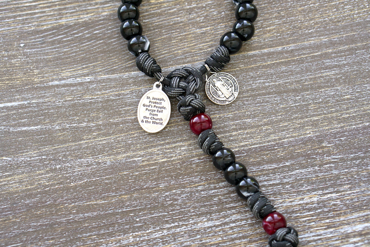 Terror of Demons - St. Joseph - Black and Red - 5 Decade Paracord Rosary featuring 12mm acrylic beads, St. Joseph and St. Benedict devotional medals, and a silver pardon crucifix for spiritual protection.