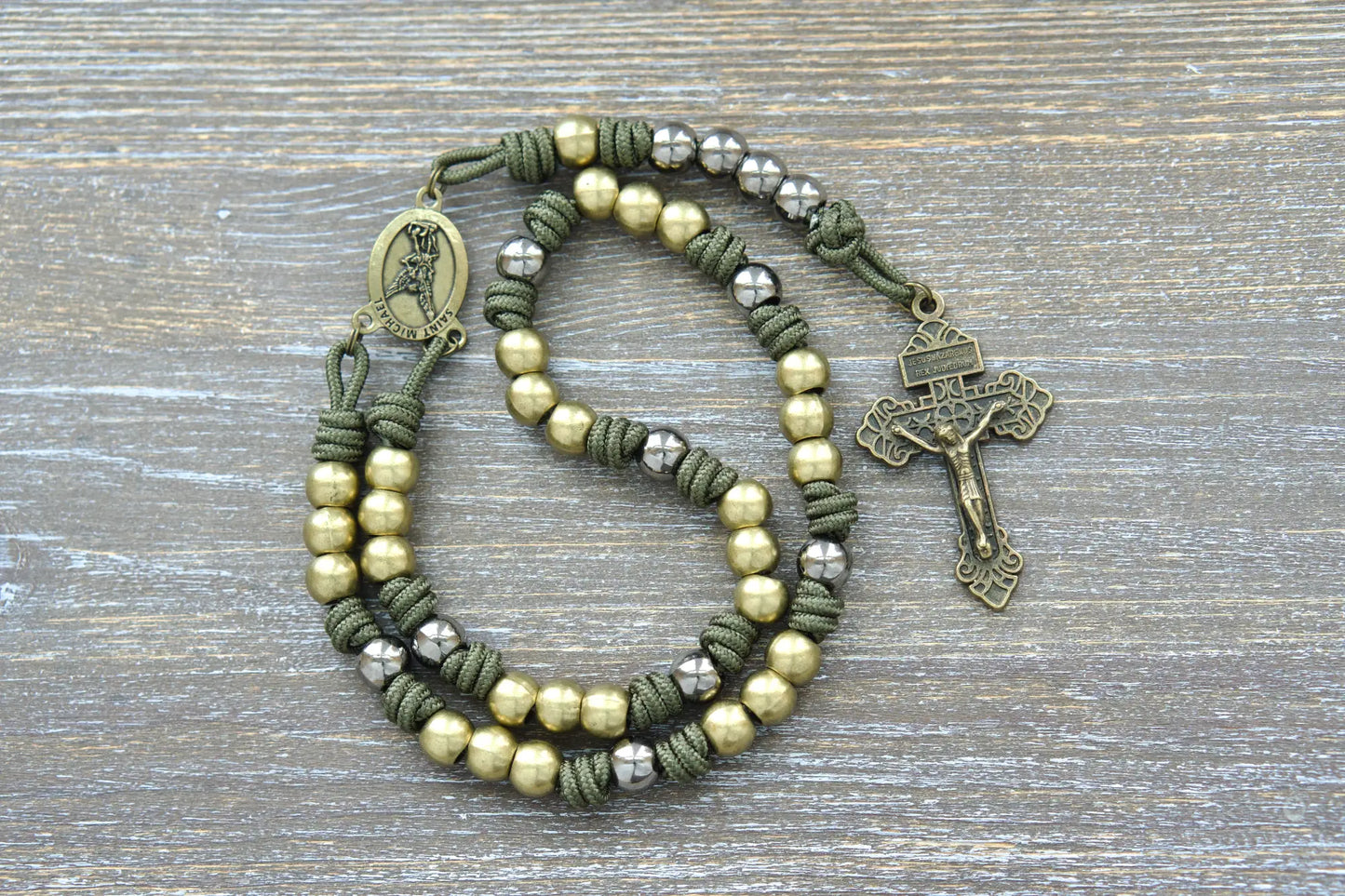 St. Michael chaplet featuring green paracord, 10mm olive metal beads, and a St. Michael medal centerpiece and pardon crucifix