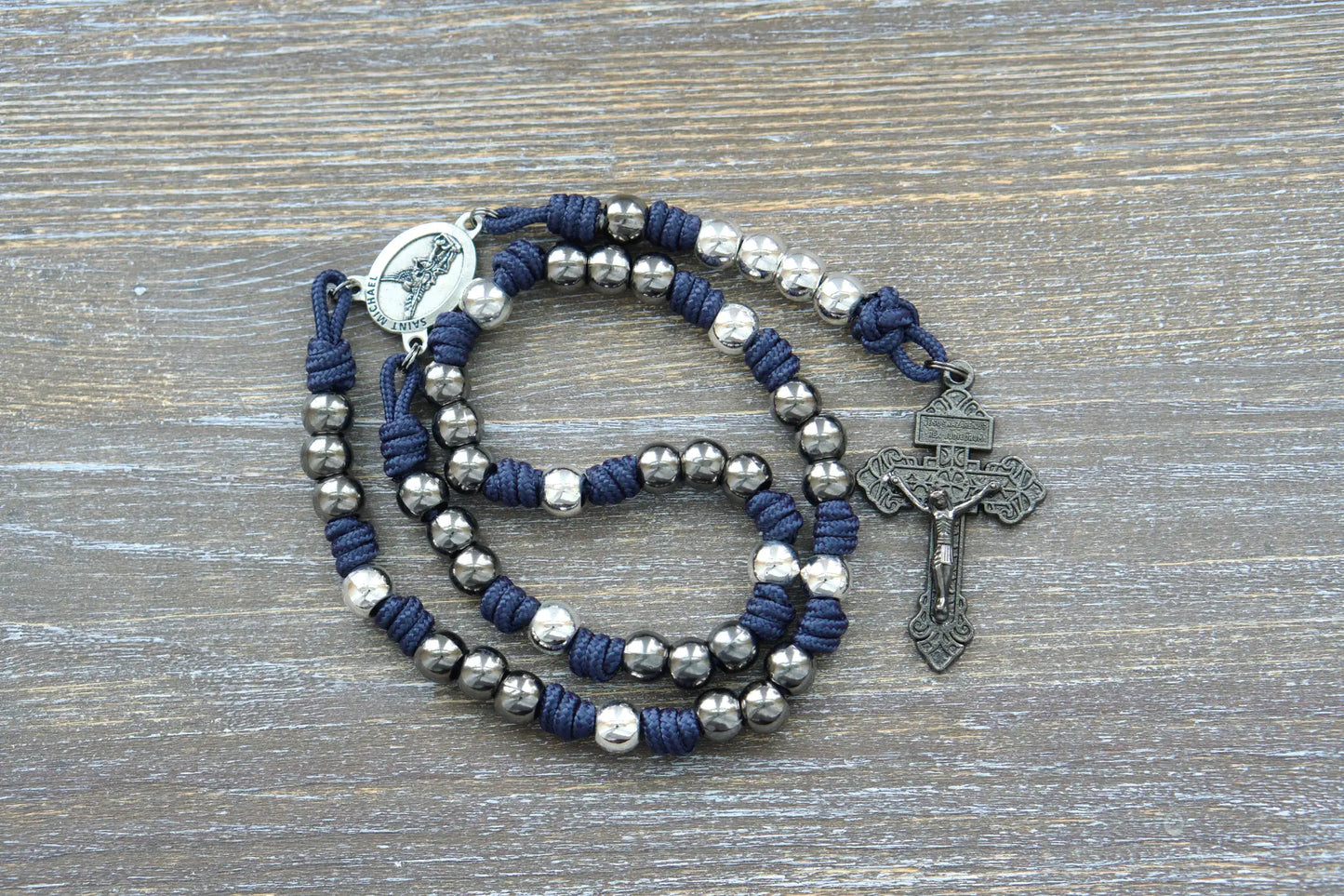 St. Michael chaplet made of black (or blue/green as specified), featuring silver medal centerpiece and 10mm metal alloy beads on durable paracord cord.