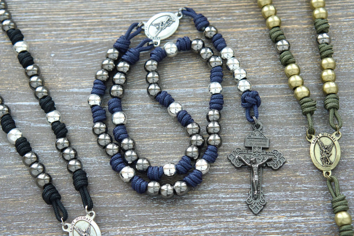 Black, blue, or green premium St. Michael paracord chaplet featuring 10mm metal alloy beads, Pardon Crucifix, and a St. Michael medal centerpiece.