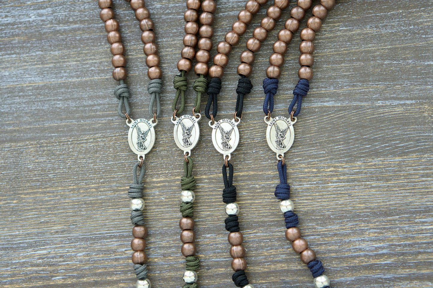 St. Michael's Sword Premium Metal Paracord Rosary: A handcrafted rosary featuring durable 275 paracord in grey, black, green, or navy blue with copper Hail Mary beads and silver Our Father beads.