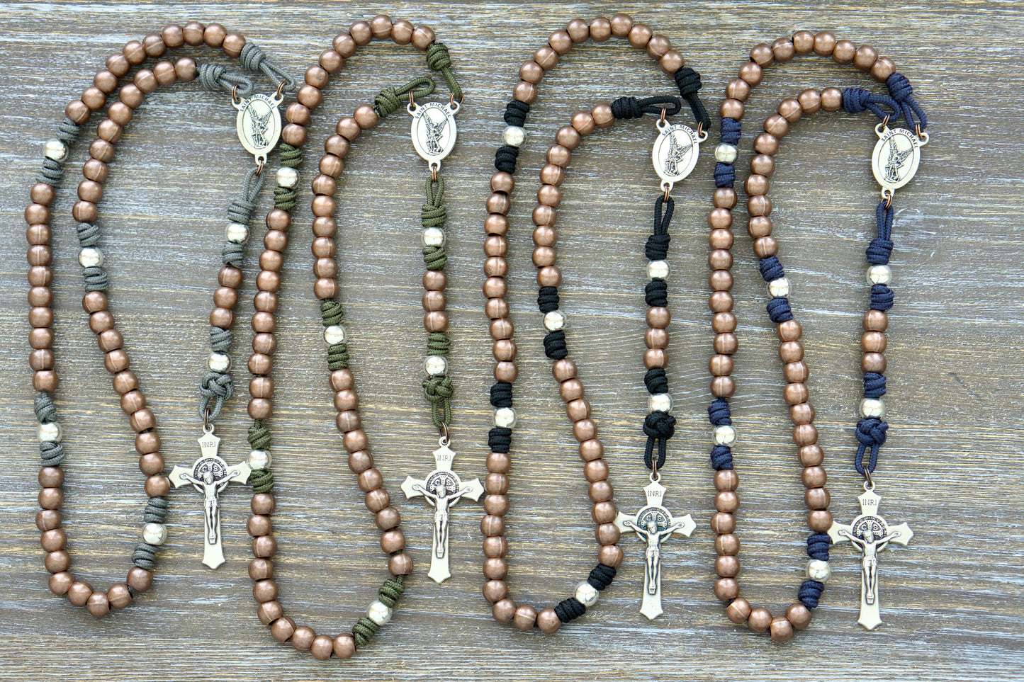 Premium paracord rosary with durable 10mm alloy metal Hail Mary (copper) and Our Father (silver) beads, featuring a radiant St. Michael centerpiece.