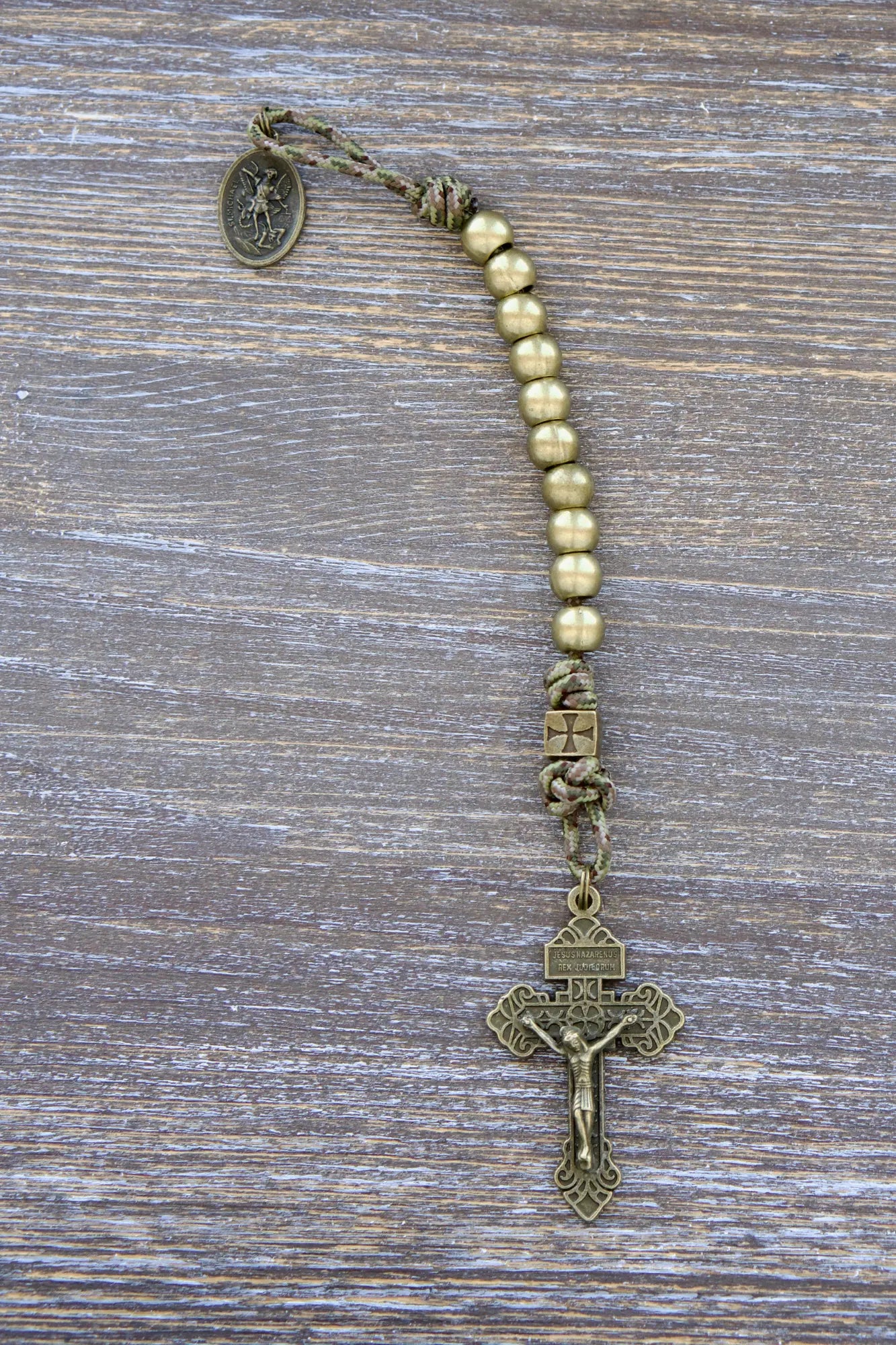 Olive green camo paracord rosary with metal beads and St. Michael medal, 2-inch pardon crucifix, crafted for faith and resilience.