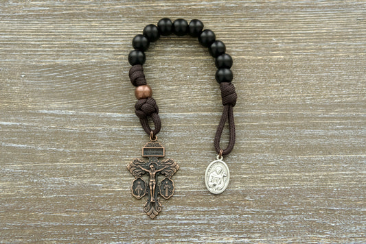 Franciscan Forge St. Francis Pocket Paracord Rosary with copper beads, black Hail Mary beads, and St. Francis medal and crucifix.